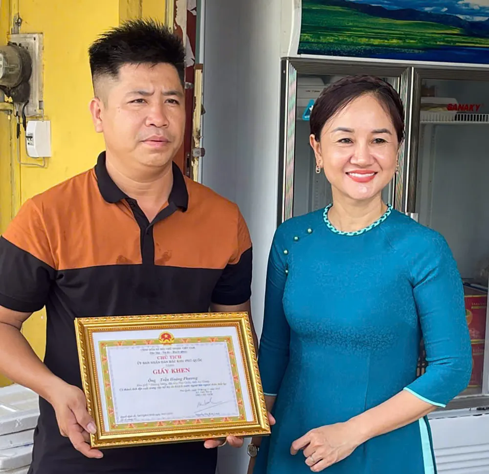 Phó Chủ tịch UBND đặc khu Phú Quốc (An Giang) Nguyễn Thị Kim Loan trao giấy khen đến anh Trần Hoàng Phương.