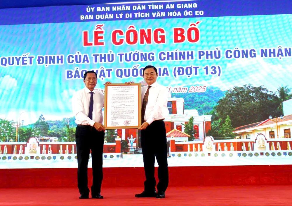 Ông Nguyễn Khánh Hiệp (bên trái), Giám đốc Sở Văn hóa và Thể thao tỉnh An Giang trao quyết định của Thủ tướng Chính phủ về việc công nhận Bảo vật quốc gia đối với 2 di tích Mộ vò Gò Cây Trâm và Đầu tượng phật Linh Sơn Bắc