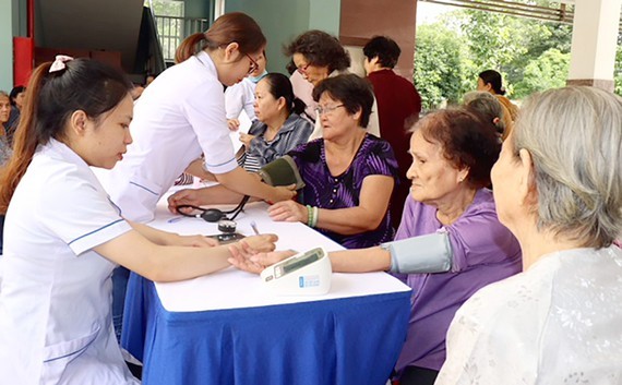 Young medical workers provide checkup to elderly people (Photo: SGGP)