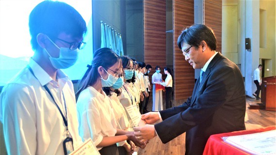 Deputy Director of the National University of Ho Chi Minh City Nguyen Minh Tam awards scholarships to students with financial difficulties and good performance (Photo: SGGP)