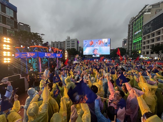 Despite rain, fans in high spirit in street watching football match ảnh 2