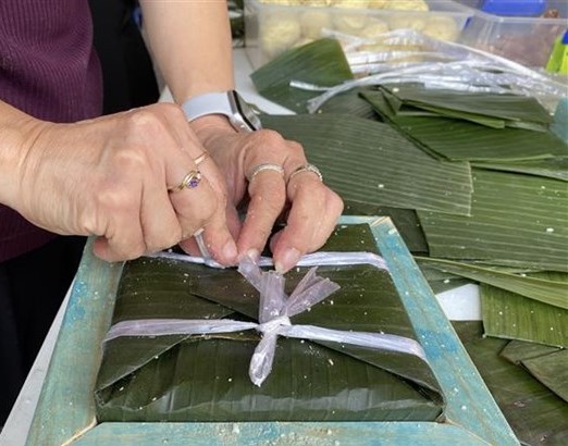 Wrapping glutinous rice cake for Tet (Photo: VNA)