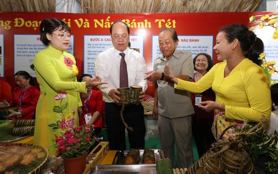 Former Standing Deputy Prime Minister Truong Hoa Binh (2nd, R) and Vice Chairman of Ho Chi Minh City People's Committee Duong Anh Duc (2nd, L) visit banh tet booth
