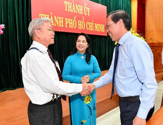 Chairman of the city People's Committee Mr. Phan Van Mai (R) talks with delegates at the meeting (Photo: SGGP)