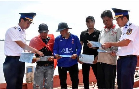 Coast guard officers provide information for fishermen in Soc Trang province. (Photo: VNA)