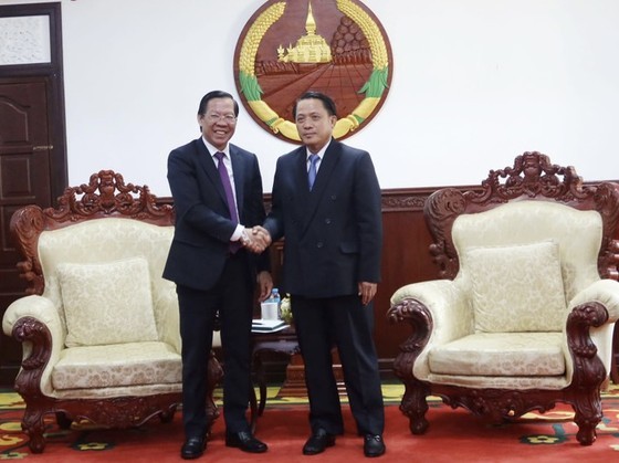 Chairman of Ho Chi Minh City People's Committee Phan Van Mai (L) shakes hands with Secretary and Governor of Savannakhet province Bounchom Ubonpasert (Photo: SGGP)