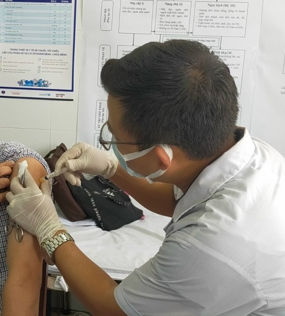 A medical worker administers vaccine to a man in Binh Duong Province