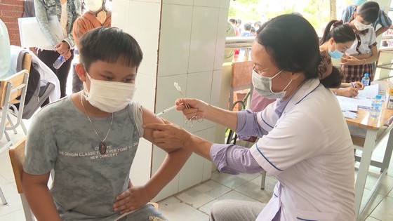 A healthcare worker administers vaccine for a schoolboy in Binh Phuoc A healthcare worker administers vaccine for a schoolboy in Binh Phuoc