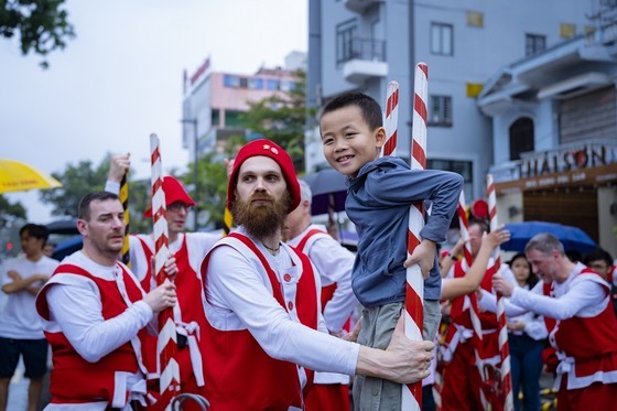Belgian artists instruct children to walk on tall sticks
