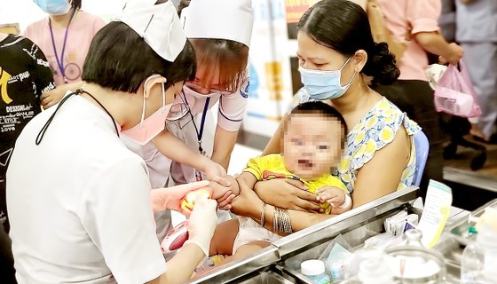 Medical workers examine a HFMD baby