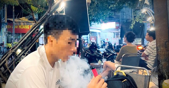 A young man uses e-cigarttes