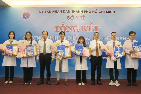 Head of the Organization Commission Nguyen Phuoc Loc gives certificates of practice to young doctors who have finished the pilot plan