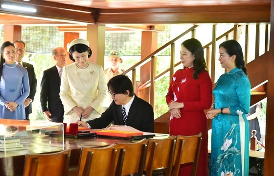 Japanese Crown Prince Akishino writes on a book at Uncle Ho's stilt house. (Photo: SGGP)