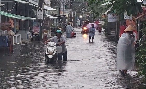Local people walk through water while their vehicle is half-sumberged Local people walk through water while their vehicle is half-sumberged