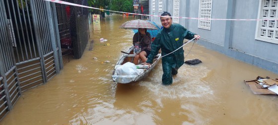 A young soldier helps relocate a resident out of flooded area