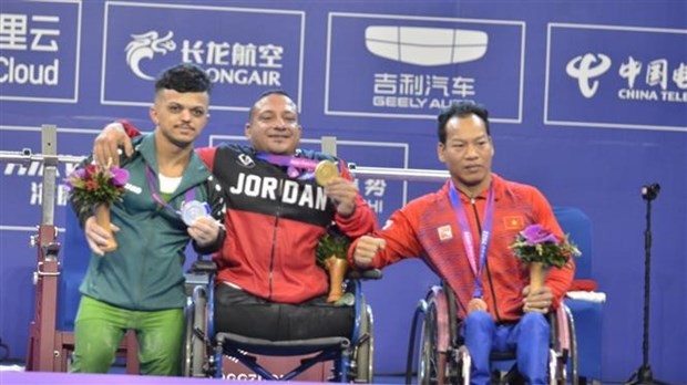 Powerlifter Le Van Cong (1, R) wins the first medal for Vietnam at Asian Para Games 2023. (Photo: VNA)
