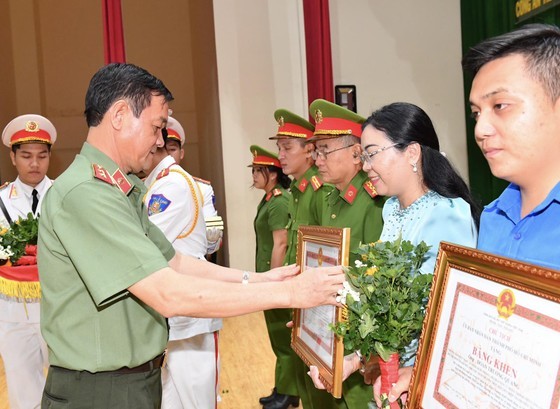 Lieutenant General Le Hong Nam awards certificates of merit from the Ho Chi Minh City People's Committee to groups and individuals with outstanding achievements. (Photo: SGGP)