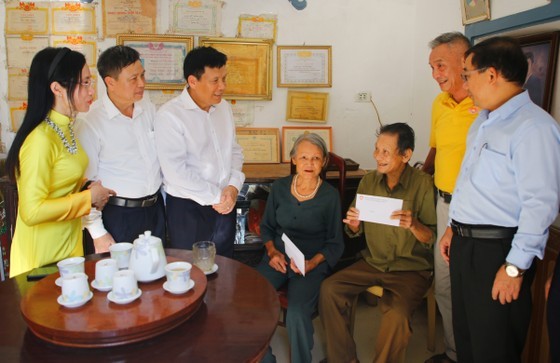 Deputy Editor-in-Chief of SGGP Newspaper (3rd from left) and local leaders give money to support Mr. Le Van Sang's family