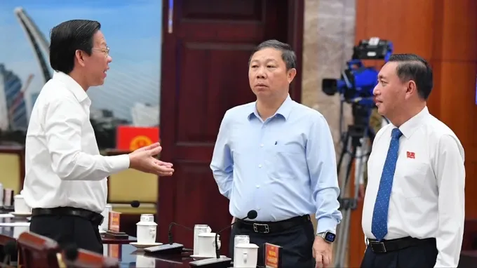 Chairman of Ho Chi Minh City People's Committee Phan Van Mai (first, L), Vice Chairman of Ho Chi Minh City People's Committee Duong Anh Duc (C) and Vice Chairman of Ho Chi Minh City People's Council Pham Thanh Kien at the meeting