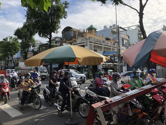 HCMC streets more crowded, shippers make long queues for Covid-19 testing ảnh 1