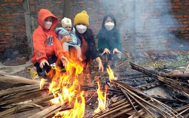People burn wood to keep warm in cold weather. (Photo: VNA)
