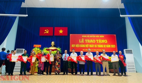 Deputy Secretary of the municipal Party Committee Nguyen Van Hieu congratulates and presents Party membership badges to old Party members of Hoc Mon District. (Photo: Chi Thach)