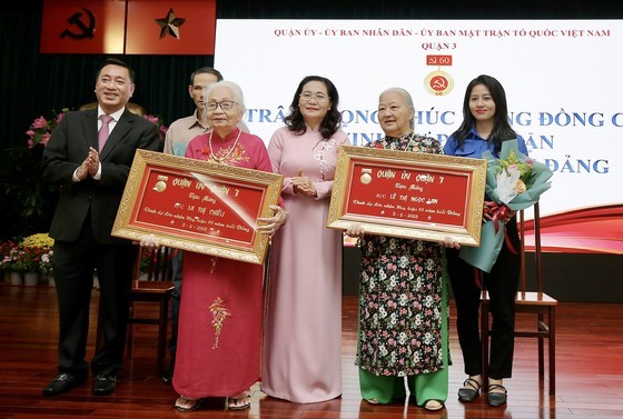 Chairwoman of the City People’s Council Nguyen Thi Le congratulates and presents 60-year Party membership badges to Party members of District 3.