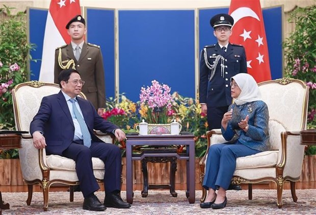 Prime Minister Pham Minh Chinh (L) and President of Singapore Halimah Yacob (Photo: VNA)