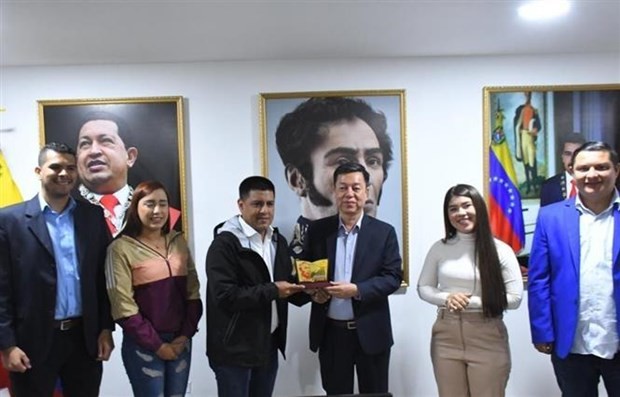 Deputy Editor-in-Chief of the Communist Review Vu Trong Lam (the third from the right) presents a souvenir to Vice President of PSUV in charge of organization affair and President of Venezuelan National Assembly Pedro Infante (Photo: VNA)