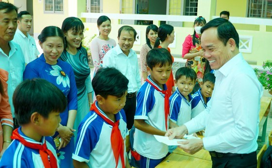Deputy Prime Minister Tran Luu Quang presents gifts to pupils at Tham Don 3 primary school.