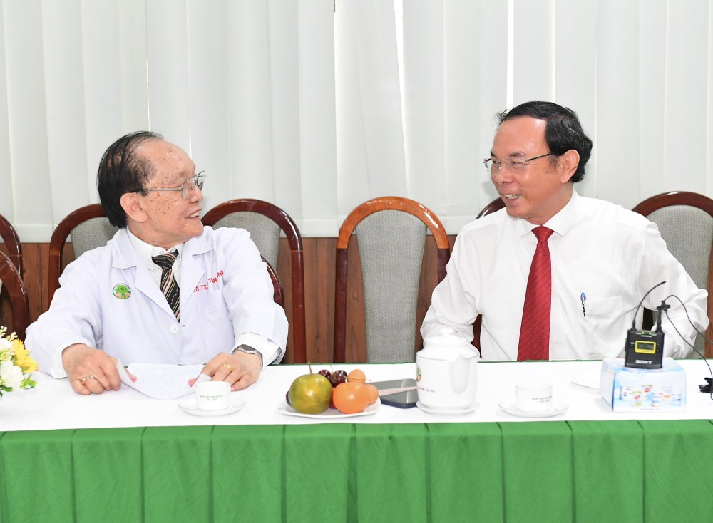 Secretary of the Municipal Party Committee Nguyen Van Nen (R) talks with Prof. Doctor Tran Dong A. (Photo: Viet Dung)