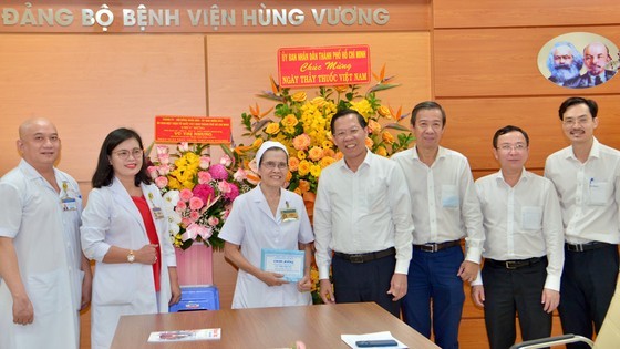 HCMC leaders pose for a photo with the medical staff of Hung Vuong Hospital. (Photo: Cao Thang)