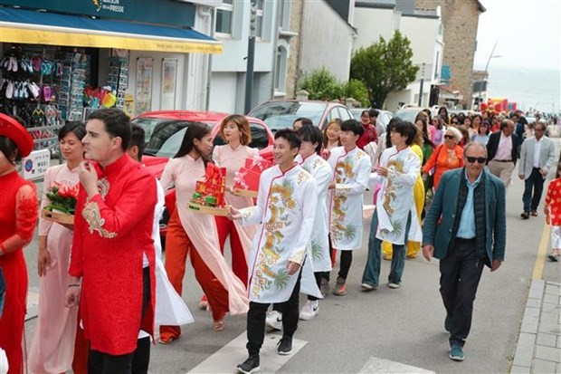 Vietnamese and international students in "ao dai", a traditional costume of Vietnam, reenact a traditional wedding of Vietnam at the festival. (Photo: VNA)