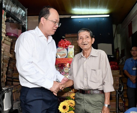 Deputy Secretary of the Ho Chi Minh City Party Committee Nguyen Ho Hai talks with war invalid Pham Van Chinh.