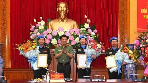 Deputy Minister of Public Security Sen. Lt. Gen. Luong Tam Quang hands over the State President's deployment decision to the three police officers on August 16. (Photo: the Ministry of Public Security)