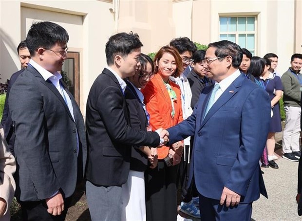 Prime Minister Pham Minh Chinh and lecturers and students of the university (Photo: VNA)