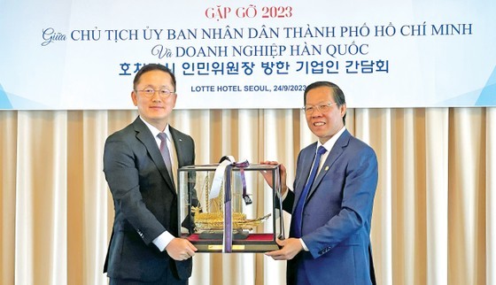 Vice Chairman of Samsung Engineering Co., Ltd. Han Sangdeok (L) presents a souvenir to Chairman of Ho Chi Minh City People's Committee Phan Van Mai.