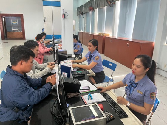 Passengers are making payment for train tickets at the counter of a station.