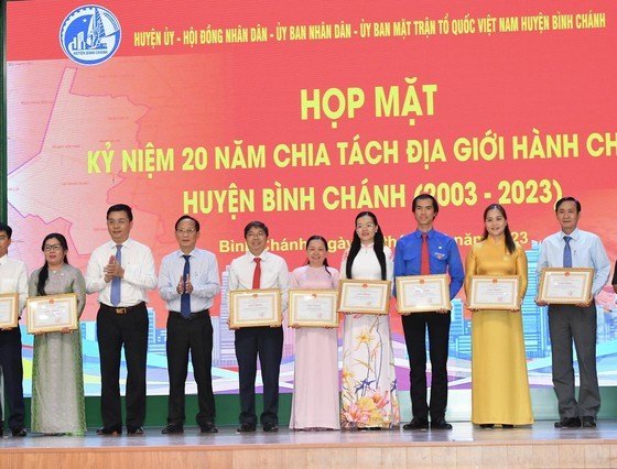 Collectives and individuals with the outstanding achievements in the district's activities and emulation movements receive certificates of merit from People's Committees of Ho Chi Minh City and Binh Chanh District. (Photo: Viet Dung)