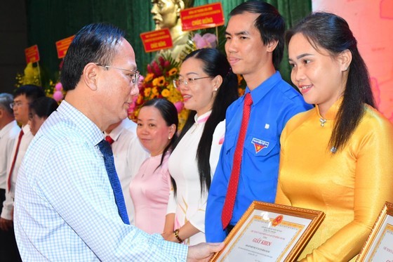 Secretary of Binh Chanh District Party Committee Tran Van Nam grants certificates of merit to outstanding individuals at the meeting. (Photo: Viet Dung)