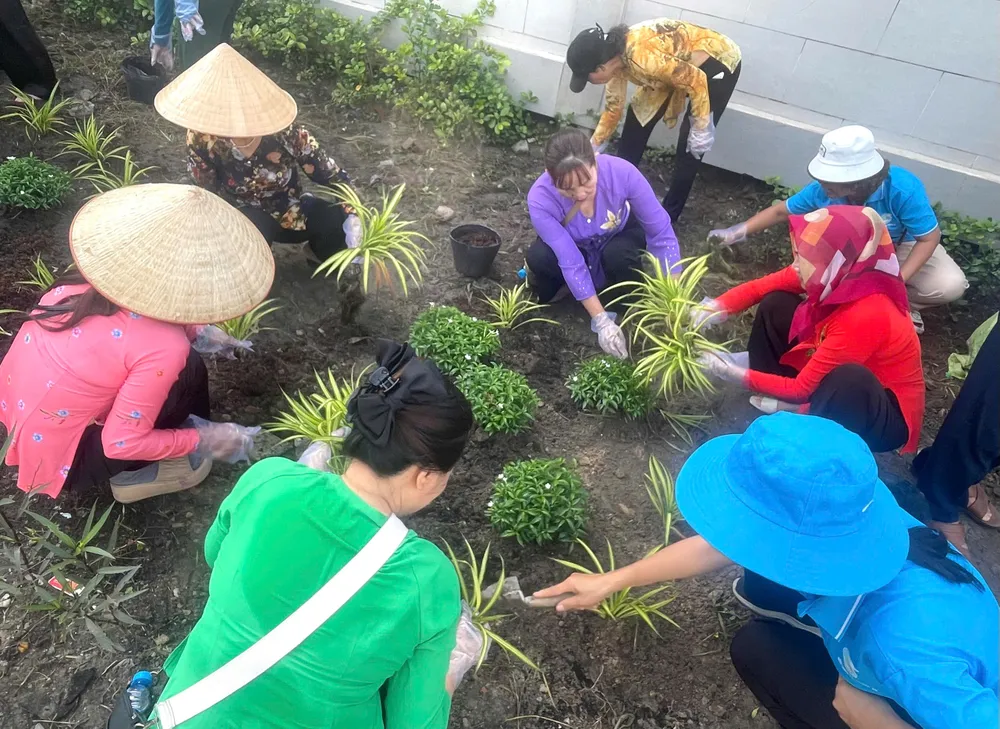Cán bộ Hội Liên hiệp phụ nữ phường Bình Hòa trồng hoa ven đường Bình Hòa 11 để chào mừng đại hội