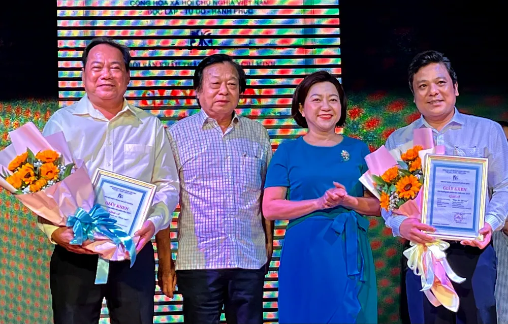 Phó Trưởng phòng VHVN Ban Tuyên giáo Thành ủy TPHCM Nguyễn Thị Ngọc Diễm và NSND Trần Ngọc Giàu trao giải A cho hai tác phẩm xuất sắc năm 2022 "Chiếc áo thiên nga" và "Câu hò đất mẹ". Ảnh: THÚY BÌNH