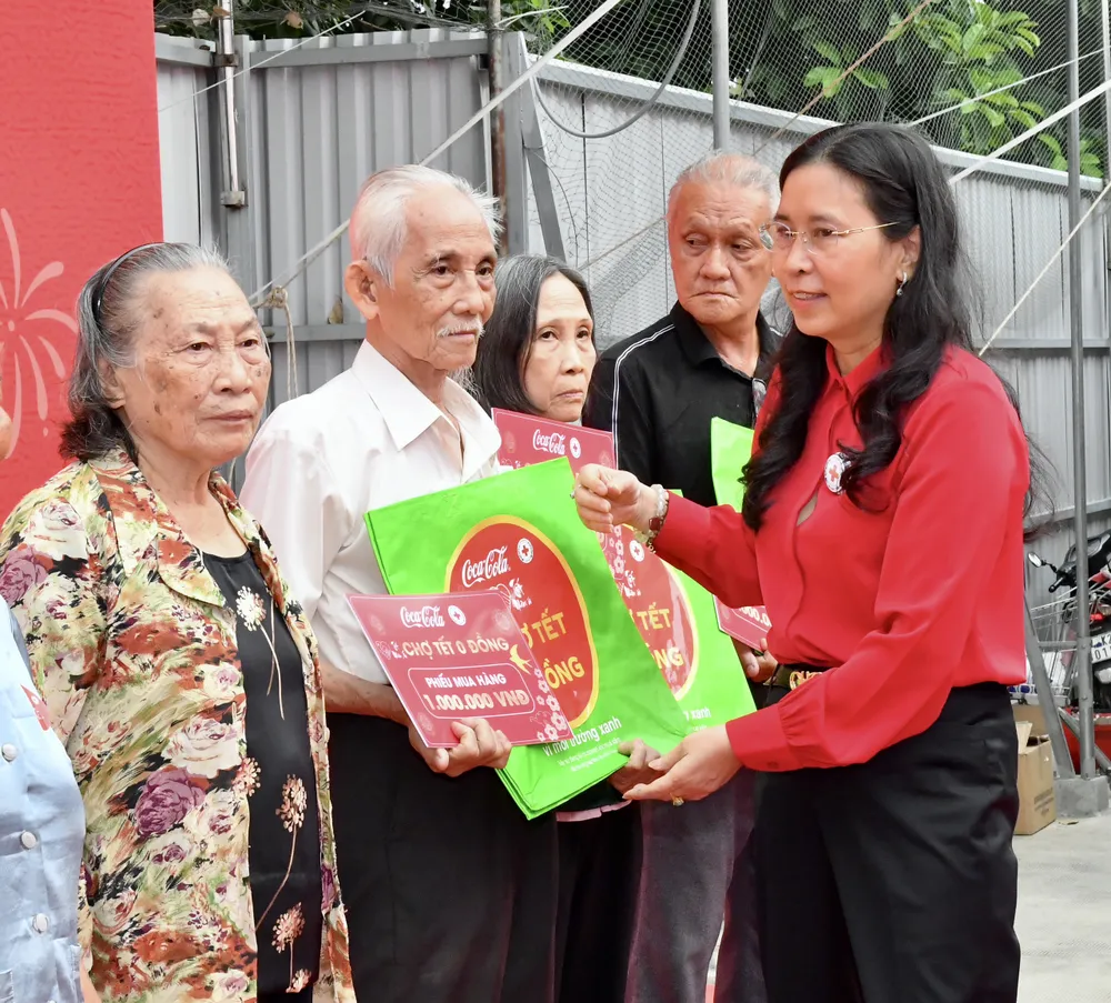 Phó Chủ tịch Trung ương Hội Chữ thập đỏ Việt Nam Huỳnh Thị Xuân Lam tặng phiếu mua hàng tết cho hộ dân hoàn cảnh khó khăn. Ảnh: VIỆT DŨNG