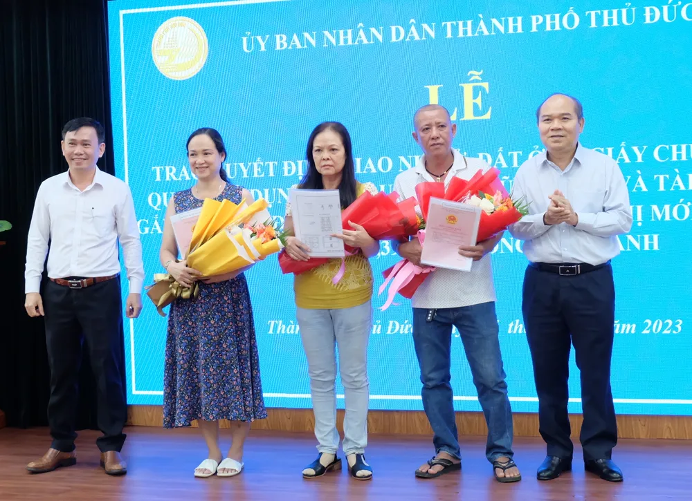 Phó Giám đốc Sở TN-MT TPHCM Trần Văn Bảy và Phó Chủ tịch UBND TP Thủ Đức Nguyễn Hữu Anh Tứ trao quyết định bố trí tái định cư, Giấy chứng nhận quyền sử dụng đất, quyền sở hữu nhà ở và tài sản khác gắn liền với đất cho các hộ dân