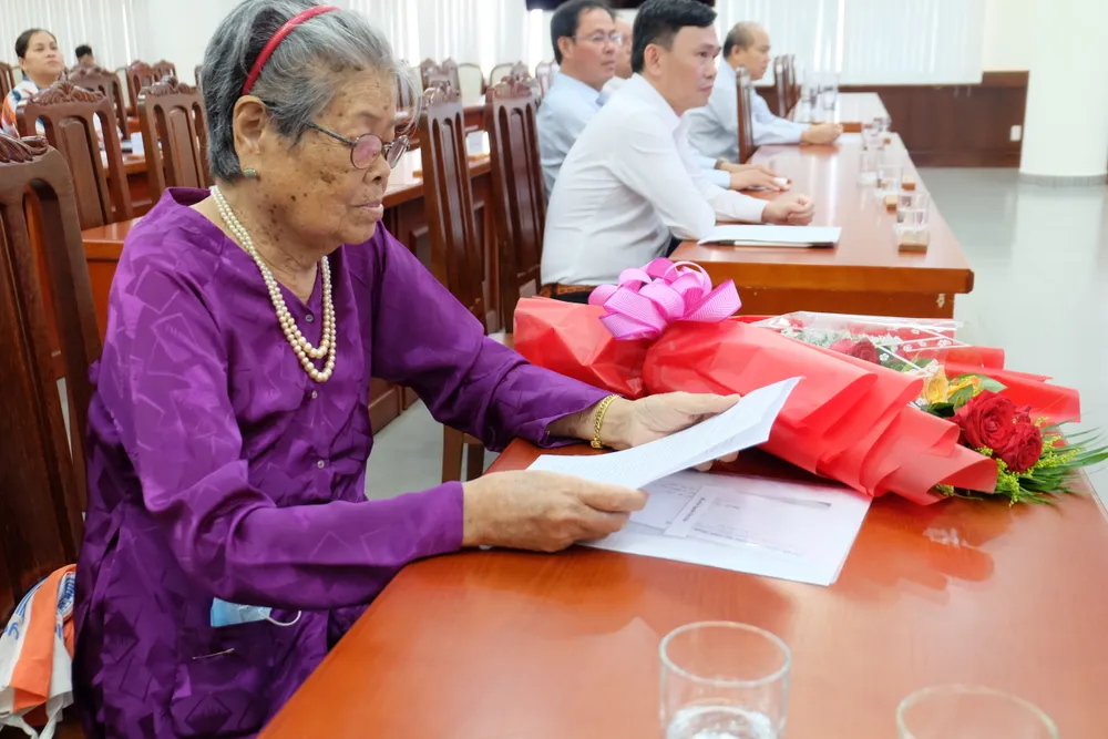 Bà Nguyễn Thị Giáp đọc các thông tin trong quyết định bố trí tái định cư vừa được địa phương trao