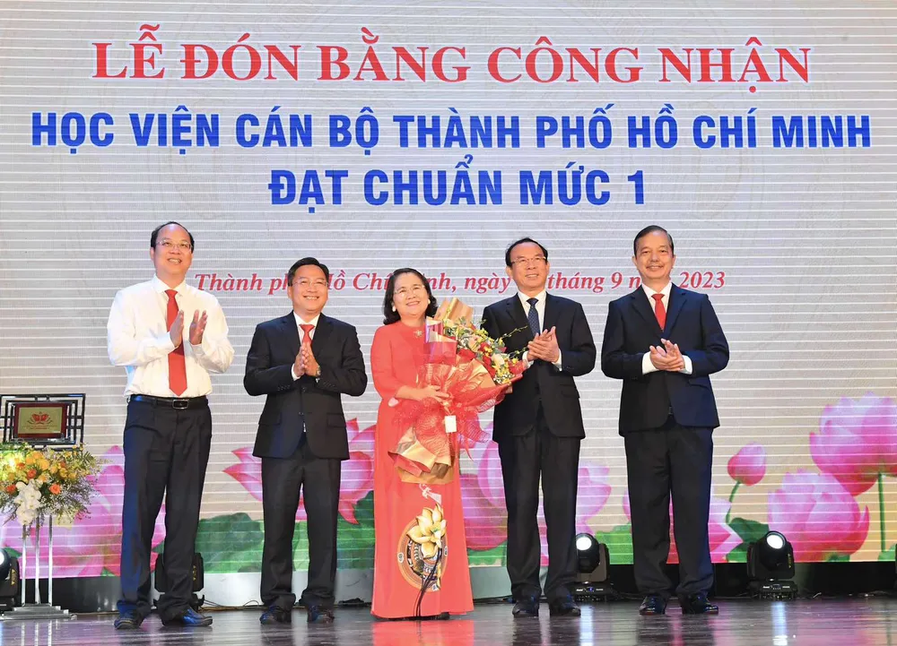 Bí thư Thành ủy TPHCM Nguyễn Văn Nên và Phó Bí thư Thành ủy TPHCM Nguyễn Hồ Hải tặng hoa chúc mừng Học viện Cán bộ TPHCM nhận Bằng công nhận đạt chuẩn mức 1. Ảnh VIỆT DŨNG