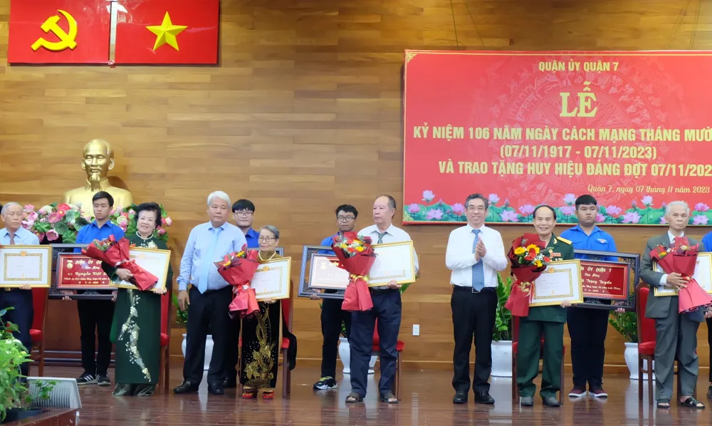 Phó Bí thư Thành ủy TPHCM Nguyễn Phước Lộc và Bí thư Quận ủy quận 7 Võ Khắc Thái chúc mừng các đồng chí nhận Huy hiệu 55 năm tuổi Đảng