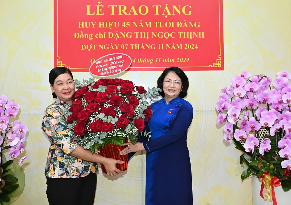 Phó Bí thư Thường trực Quận ủy quận 1 Hoàng Thị Tố Nga chúc mừng đồng chí Đặng Thị Ngọc Thịnh nhận Huy hiệu 45 năm tuổi Đảng. Ảnh: VIỆT DŨNG