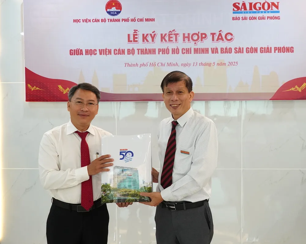 Phó Tổng Biên tập phụ trách Báo SGGP Nguyễn Khắc Văn tặng quà lưu niệm đến Học viện Cán bộ TPHCM. Ảnh: CHÍ THẠCH