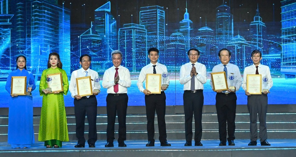 Deputy Secretary of the Ho Chi Minh City Party Committee Dang Minh Thong (4th, L) and director of the Ho Chi Minh City Department of Science and Technology Lam Dinh Thang (3rd, R) give the award to individual and group authors in the field of media. (Photo: SGGP)